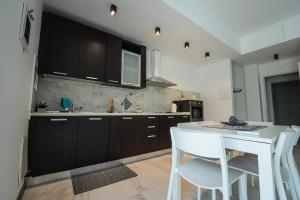 a kitchen with a white table and white chairs at La Casa di Sossy in Civitanova Marche
