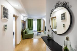 un soggiorno con specchio e divano verde di FandositBoutique a Ştefăneştii de Jos