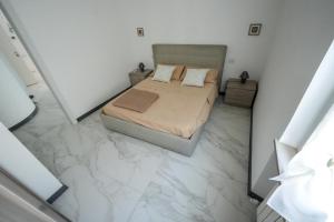 a bedroom with a bed and marble floor at La Casa di Sossy in Civitanova Marche