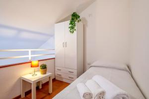 ein Schlafzimmer mit einem Bett und einem weißen Schrank in der Unterkunft Panoramic Bastioni Sea View in Alghero