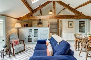 a living room with a blue couch and a table at The Hayloft in Hook Norton