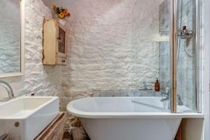 a white bathroom with a tub and a sink at The Hayloft in Hook Norton +16 photos