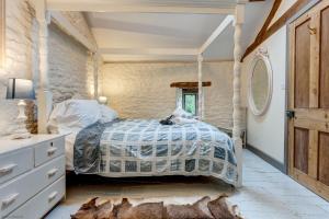 a bedroom with a bed and a dresser and a window at The Hayloft in Hook Norton