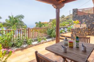 una mesa de madera en el balcón de una casa en Lightbooking La Morita Villa de Mazo con piscina, en Mazo