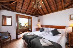 1 Schlafzimmer mit 2 Betten und Holzdecke in der Unterkunft Lightbooking La Morita Villa de Mazo con piscina in Mazo