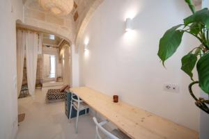 een kamer met een houten tafel en een plant bij WePuglia - Dimora Elia in Polignano a Mare