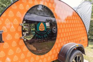 an orange camping trailer with a window on it at Camping Les Pins de Sel in Saint-Augustin
