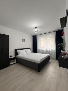 Un dormitorio con una cama grande y una ventana. en Apartament R - Brașov, en Brasov