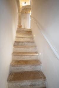 een trap in een gebouw met witte muren en betonnen trappen bij WePuglia - Dimora Elia in Polignano a Mare