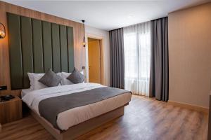 a bedroom with a large bed and a large window at Perast City Hotel in Antalya