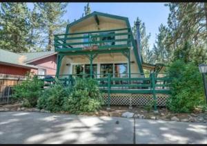 una casa grande con una barandilla verde en la parte delantera en The Bears lair Perfect for Family w/all amenities, en Big Bear City