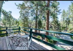 un par de sillas sentadas en una terraza de madera en The Bears lair Perfect for Family w/all amenities, en Big Bear City