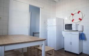 a kitchen with a table and a refrigerator at A Casa do Porto in Burela de Cabo