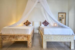 Postel nebo postele na pokoji v ubytování Arungan Villas
