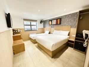 Cette chambre comprend deux lits et une télévision. dans l'établissement Eurotraveller Hotel- Express (Elephant & Castle), à Londres