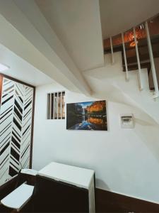 una camera bianca con un divano e una foto sul muro di Cua Bac Modern Home in Central Hanoi a Hanoi