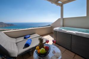 a room with a tub and a table with a bowl of fruit at Stefanos Village Hotel in Plakias