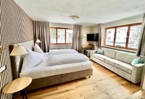 a hotel room with a bed and a couch at Haus Schrofenstein in Lech am Arlberg