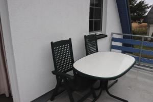 a white table and two chairs on a balcony at Pension Martens - Mansadenwohnung in Wieck