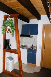 a small kitchen with blue cabinets and a ladder at Pension Martens - Mansadenwohnung in Wieck