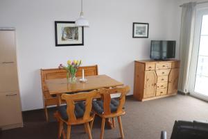 a dining room table with two chairs and a television at Pension Martens - Ella in Wieck