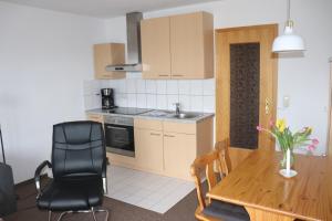 a kitchen and dining room with a table and chairs at Pension Martens - Ella in Wieck