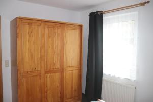 a wooden cabinet in a room with a window at Pension Martens - Ella in Wieck