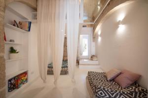 a bedroom with white curtains and a bed in a room at WePuglia - Dimora Elia in Polignano a Mare +47 photos