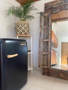 - un réfrigérateur noir dans une chambre avec une plante en pot dans l'établissement Quintinha Boheme…, à Aljezur