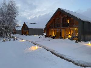 una casa en la nieve con luces delante en Krasne Residence & SPA - STREFA CISZY en Krasne