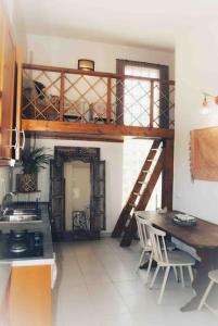 uma cozinha com uma cama alta, uma mesa e cadeiras em Quintinha Boheme… em Aljezur