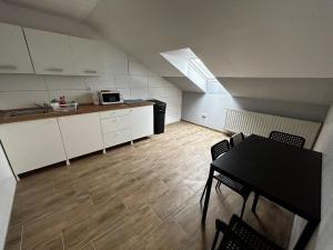 Boardinghouse Wendelstein في فينديلشتآين: غرفة مع مطبخ وطاولة مع كراسي