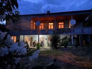 una casa con persone sedute sul portico di notte di Guest House Shateau a Sagarejo