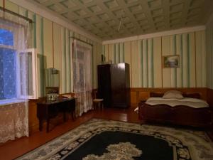 una camera da letto con un letto, un tavolo e una finestra di Guest House Shateau a Sagarejo