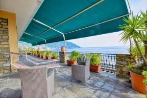 eine Terrasse mit Stühlen und Meerblick in der Unterkunft Una Terrazza sul Golfo Paradiso in Recco