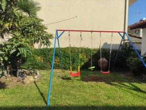 a swing set in a yard with grass at Polynikis Apartment in Nikiti