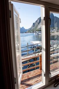 een raam met uitzicht op een steiger met boten in het water bij Authentic central located cabin close to Reinebringen Lofoten in Reine