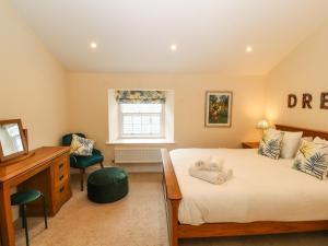 a bedroom with a bed and a desk and a window at 4 Martindales Yard in Kendal