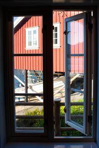 an open window with a view of a red building at Authentic central located cabin close to Reinebringen Lofoten in Reine