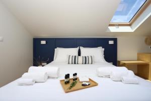 una camera da letto con un grande letto bianco con testiera blu di ONAR OURANOUPOLIS a Ouranoupoli