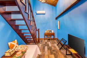 uma sala de estar com paredes azuis e uma escada de madeira em Beijing Shixi Inn - Wangfujing Nanluoguxiang Branch em Pequim