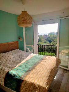 a bedroom with a bed and a large window at Ambeille Collioure in Collioure