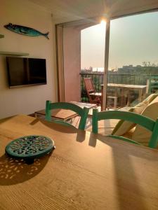 a wooden table with two green chairs and a window at Ambeille Collioure in Collioure