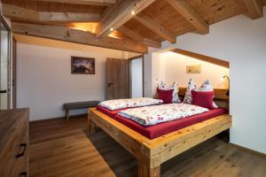 um quarto com uma cama grande e almofadas vermelhas em Ferienwohnung Neumayer em Berchtesgaden