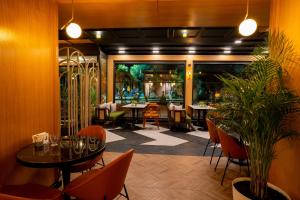 un restaurant avec des tables, des chaises et des plantes dans l'établissement Perast City Hotel, à Antalya