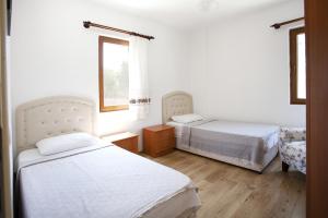 sypialnia z 2 łóżkami i oknem w obiekcie House w Balcony and Garden 1 min to Beach in Datca w mieście Datça
