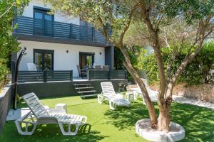 a group of chairs and a tree in a yard at Apartmani PARDON in Pag