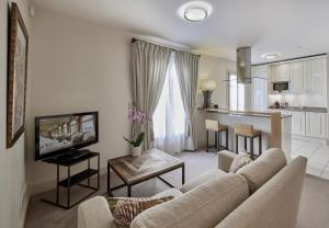 a living room with a couch and a kitchen at La Résidence de La Réserve in Beaulieu-sur-Mer