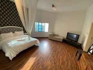 a bedroom with a bed and a flat screen tv at Relaxing Private Rooms in Compound Housing near Burj Alarab Villa 124 in Dubai
