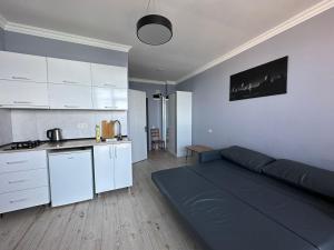 uma sala de estar com um sofá e uma cozinha em BatumiBliss1 em Batumi